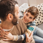 young boy hugging father