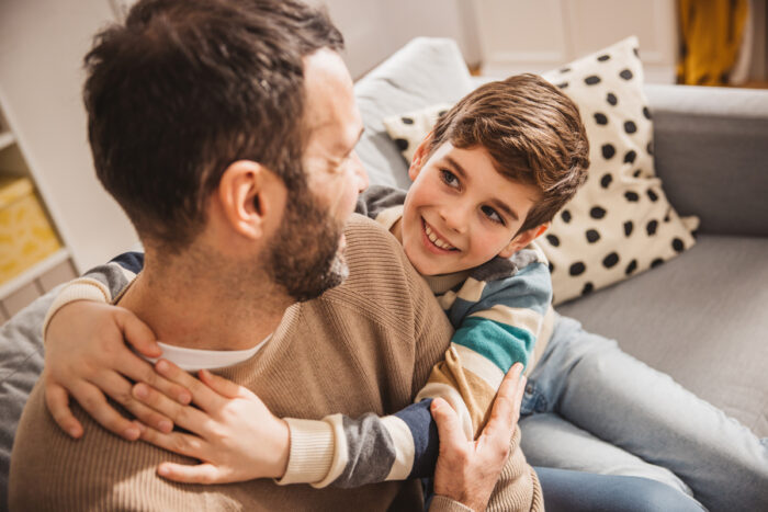 young boy hugging father