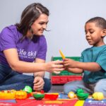 young boy and LSAA technician playing with toy fruit