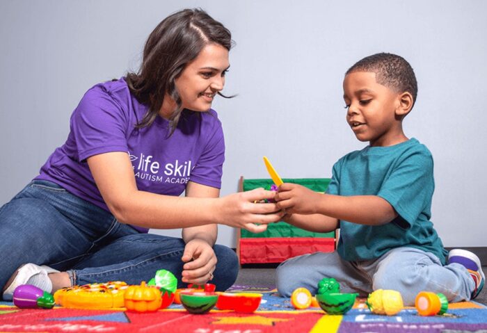 young boy and LSAA technician playing with toy fruit