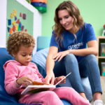girl and behavior technician reading a book